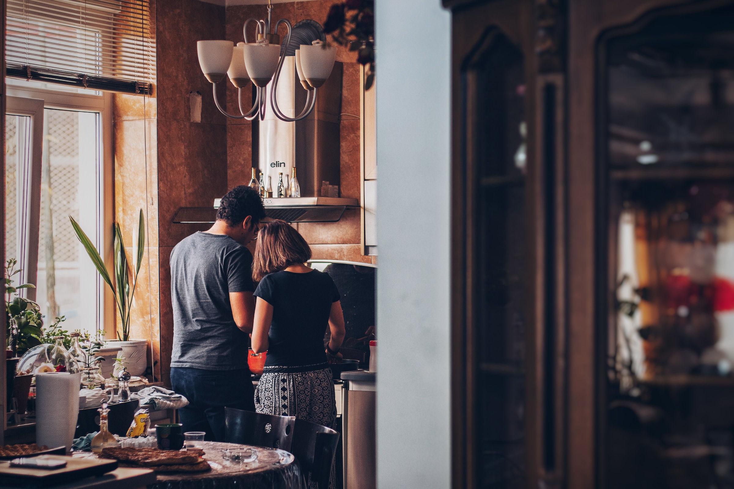 Duas pessoas em cozinhando em um ambiente que aconchegante.